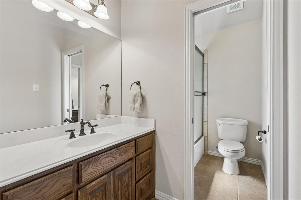 600 Lonesome Trail Haslet, TX 76052 - Photo 28 of 36 a bathroom with a sink a toilet and a large mirror