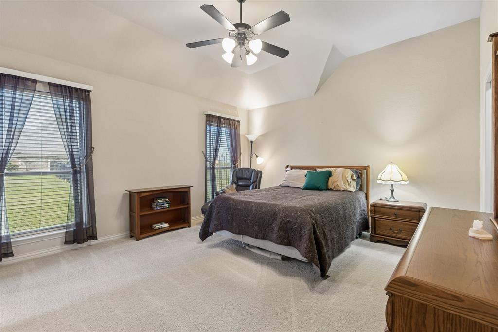 600 Lonesome Trail Haslet, TX 76052 - Photo 29 of 36 a spacious bedroom with a bed and a chandelier