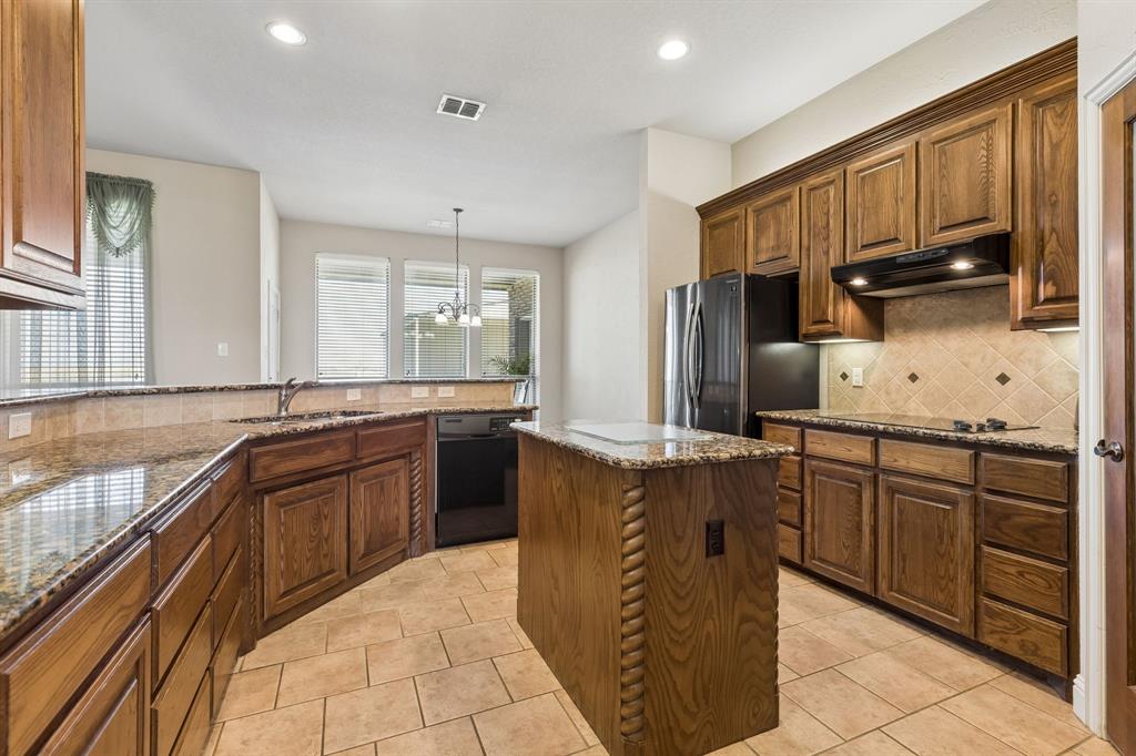 600 Lonesome Trail Haslet, TX 76052 - Photo 3 of 36 a kitchen with stainless steel appliances granite countertop wooden cabinets a sink dishwasher a stove and a refrigerator