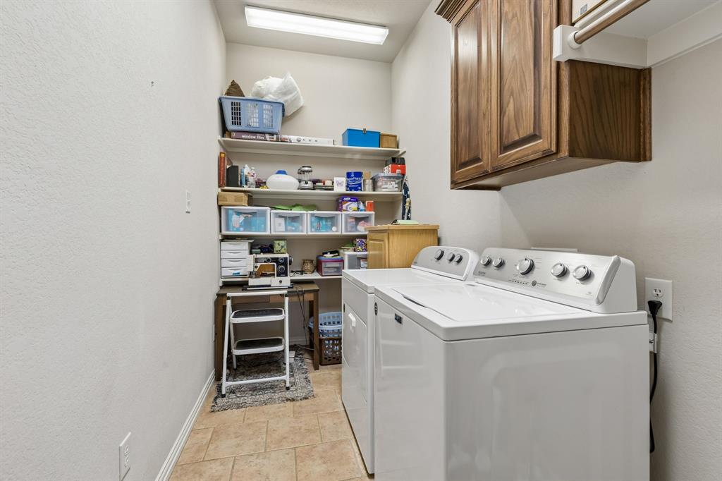 600 Lonesome Trail Haslet, TX 76052 - Photo 31 of 36 a view of washer and dryer with kitchen in the background