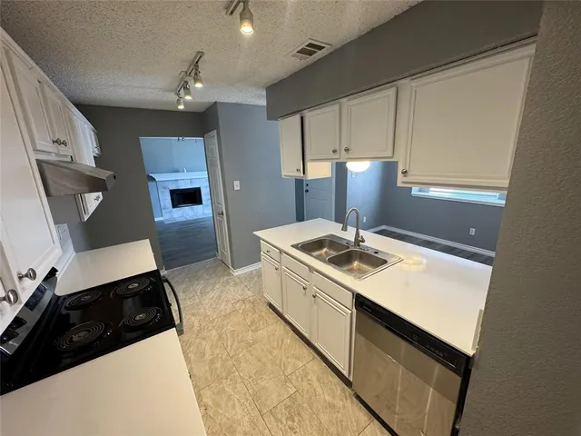 a kitchen with a sink stove and cabinets