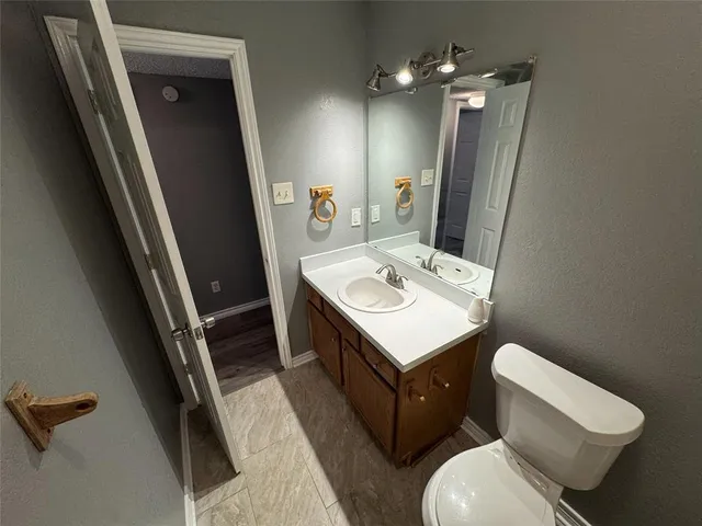 a bathroom with a sink a toilet a mirror and vanity