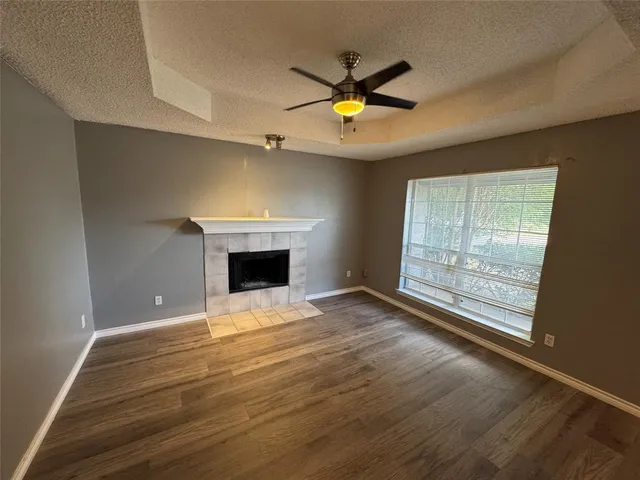 a view of an empty room with a window and a fireplace