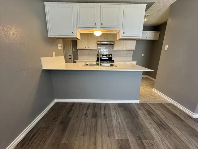 a room with wooden floor and cabinets