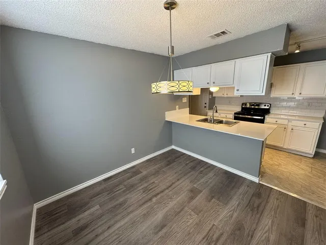 a kitchen with stainless steel appliances granite countertop a sink a stove top oven a counter space and cabinets