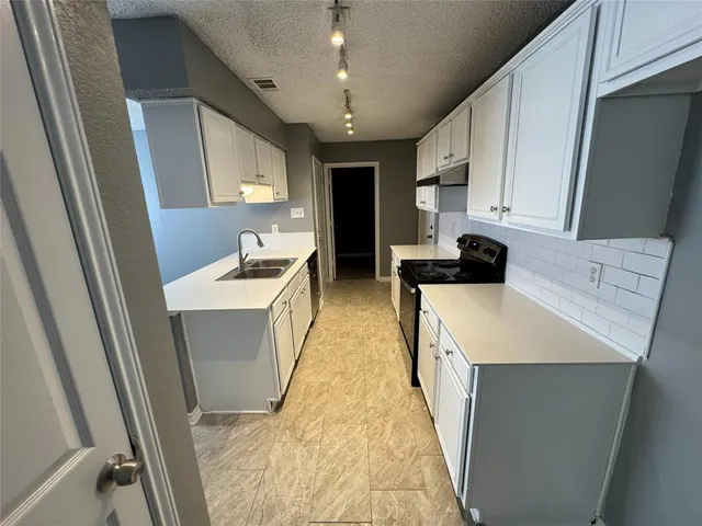 a kitchen with kitchen island a sink a refrigerator and a stove