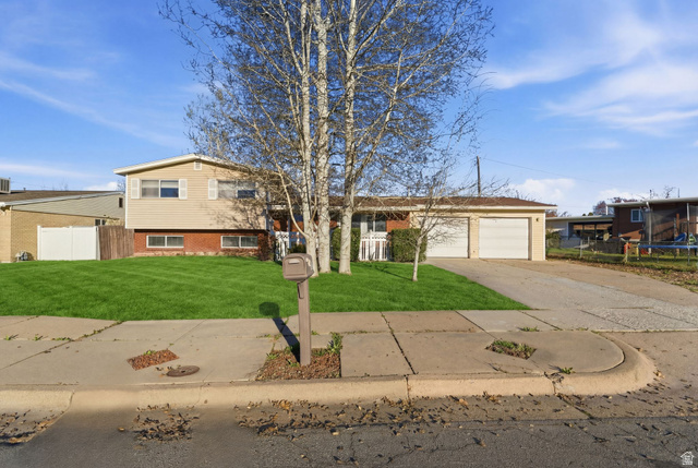 929 Amethyst Street Layton, UT 84041 - Photo 1 of 1 Tri-level home featuring brick siding, a garage, and concrete driveway