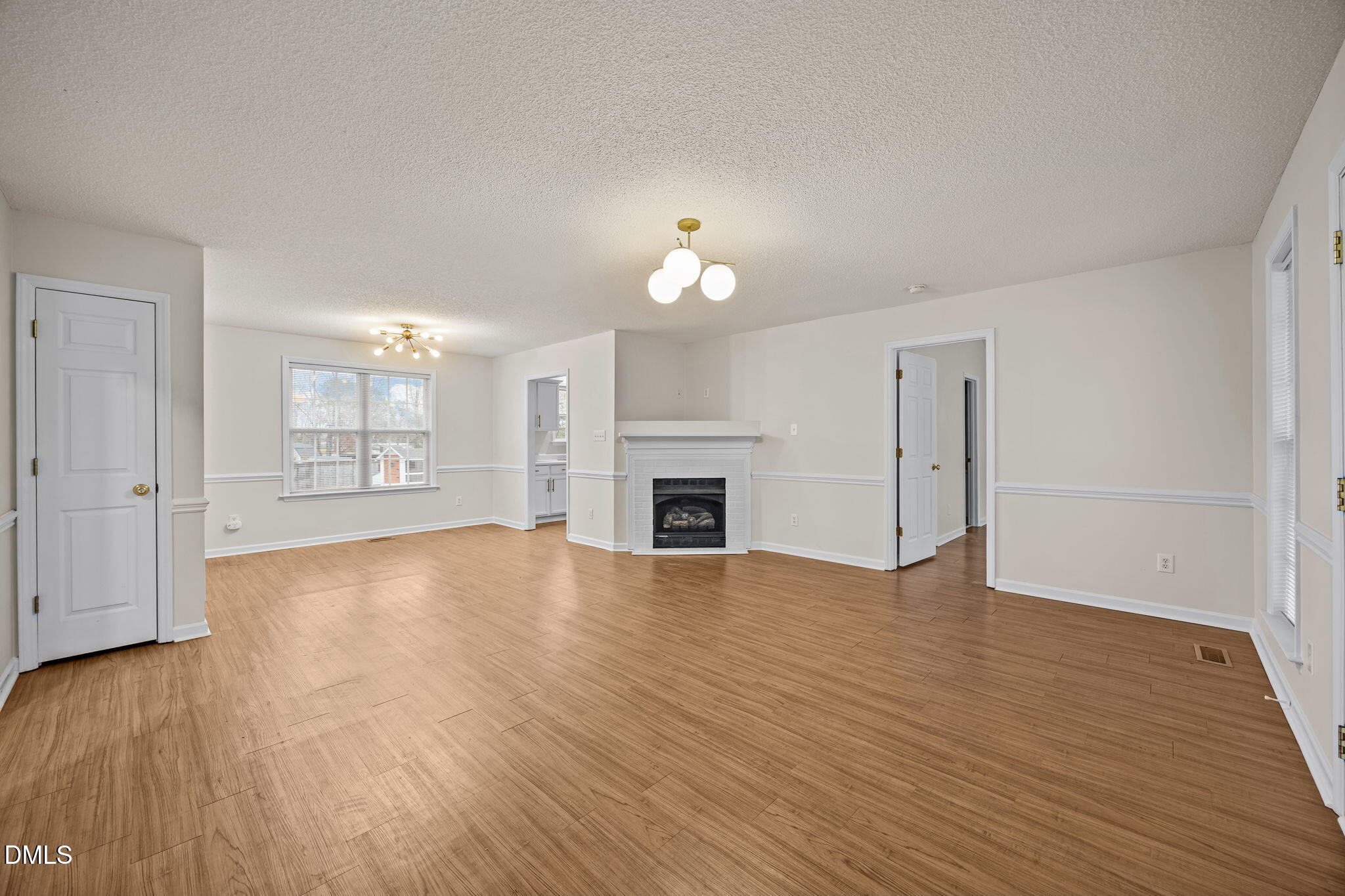 71 Rosa Circle Willow Spring, NC 27592 - Photo 6 of 31 an empty room with wooden floor fireplace and windows