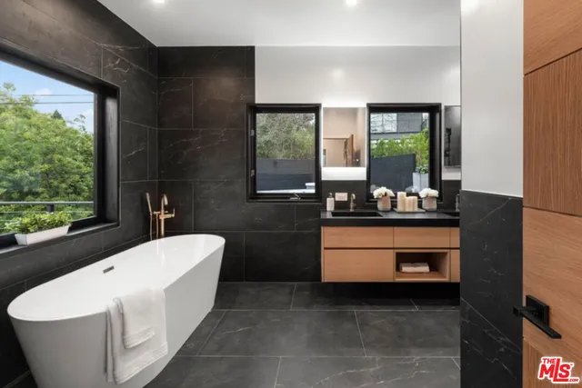 a bathroom with a bathtub sink and mirror