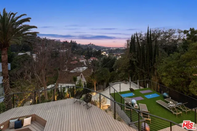 a view of a terrace with furniture and a garden