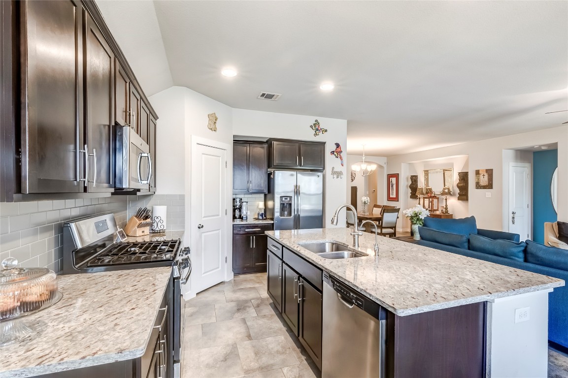 231 Windswept Way Kyle, TX 78640 - Photo 1 of 39 a kitchen with granite countertop stainless steel appliances a sink stove top oven and cabinets
