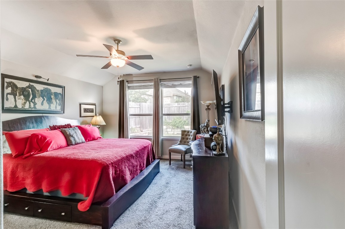 231 Windswept Way Kyle, TX 78640 - Photo 11 of 39 a bedroom with a bed and a chandelier