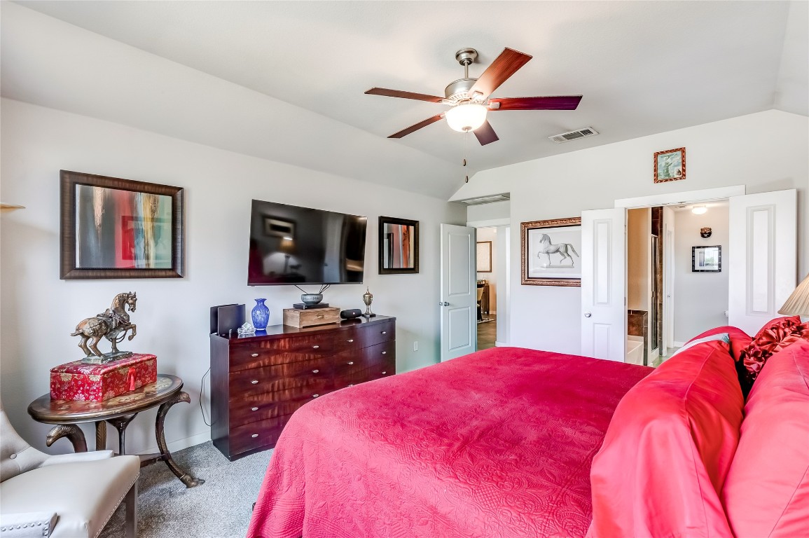 231 Windswept Way Kyle, TX 78640 - Photo 13 of 39 a bedroom with a bed and a flat screen tv