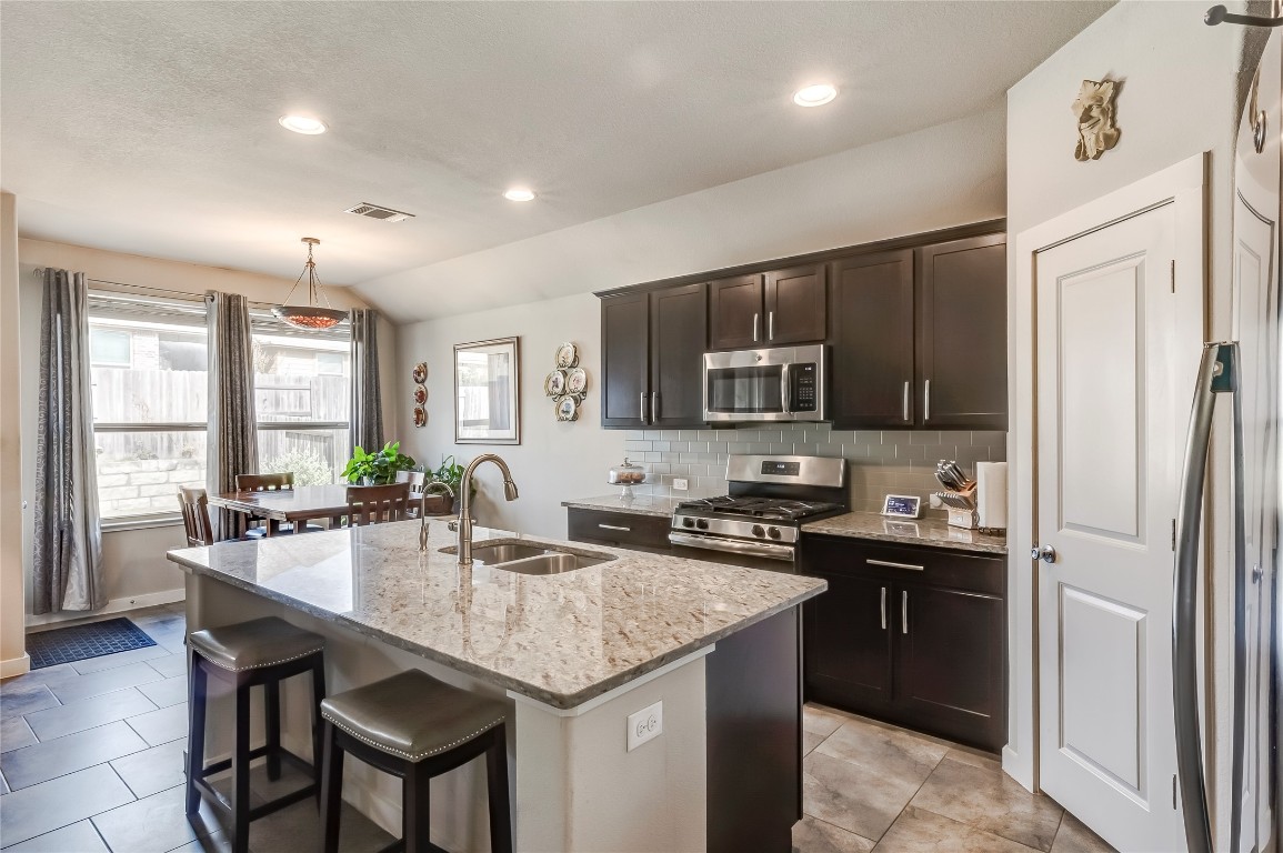 231 Windswept Way Kyle, TX 78640 - Photo 4 of 39 a kitchen with granite countertop a sink appliances and cabinets
