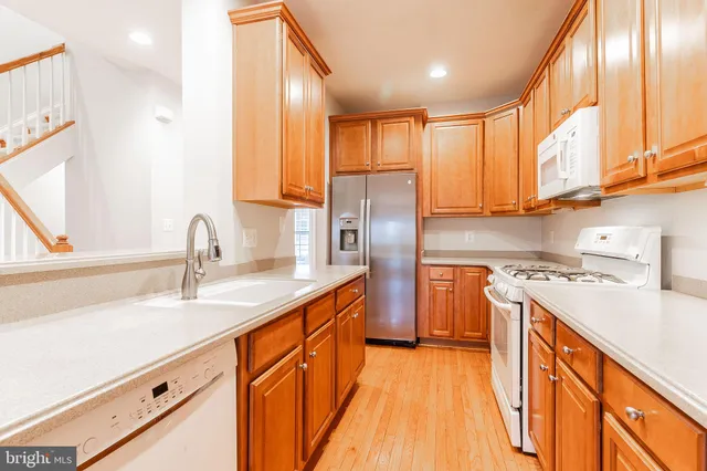a kitchen with stainless steel appliances granite countertop a sink a stove and a refrigerator