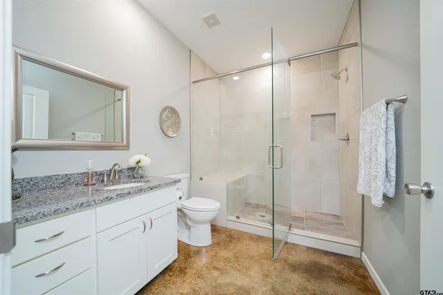 a spacious bathroom with a granite countertop sink mirror toilet and shower