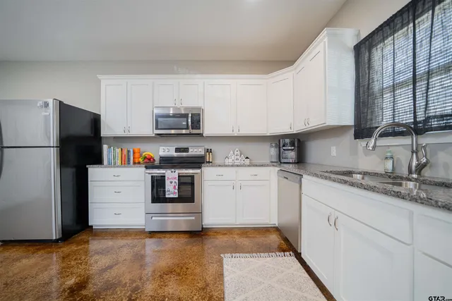 a kitchen with cabinets stainless steel appliances and a window