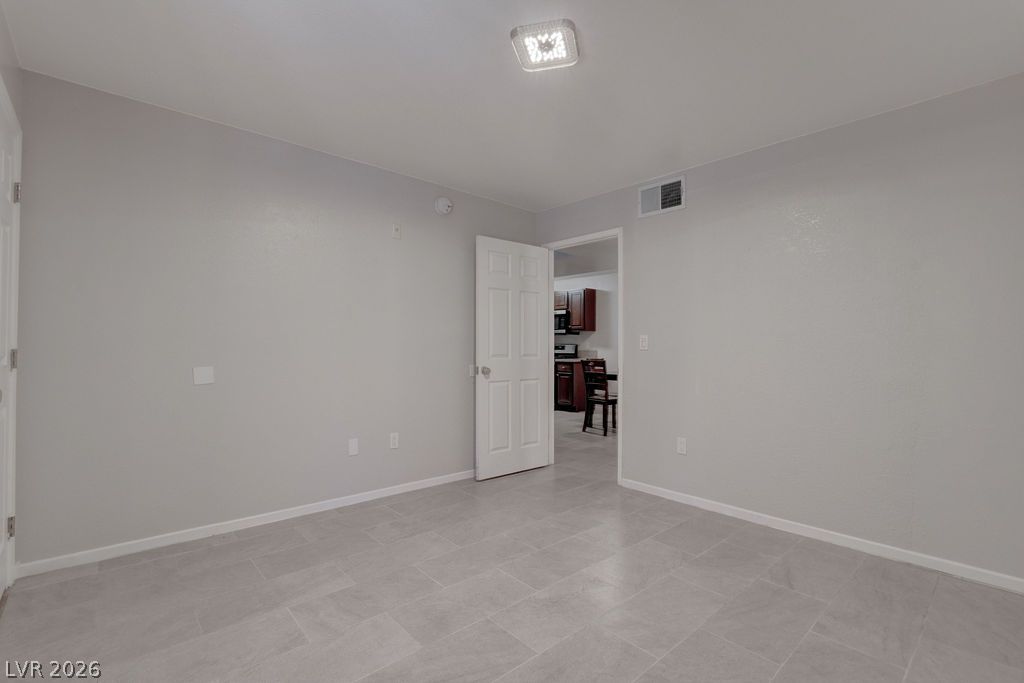 7885 West Flamingo Road, Unit 1016 Las Vegas, NV 89147 - Photo 16 of 24 The generously sized living space is laid with fresh tile flooring, leading into an adjacent kitchen area.