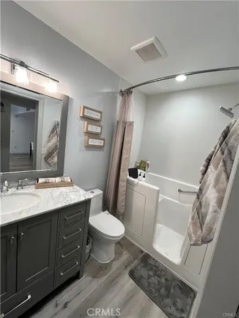 a bathroom with a granite countertop toilet sink and mirror