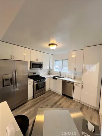 a large kitchen with a refrigerator a stove top oven a sink and dishwasher