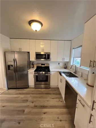 a kitchen with granite countertop a refrigerator and a sink