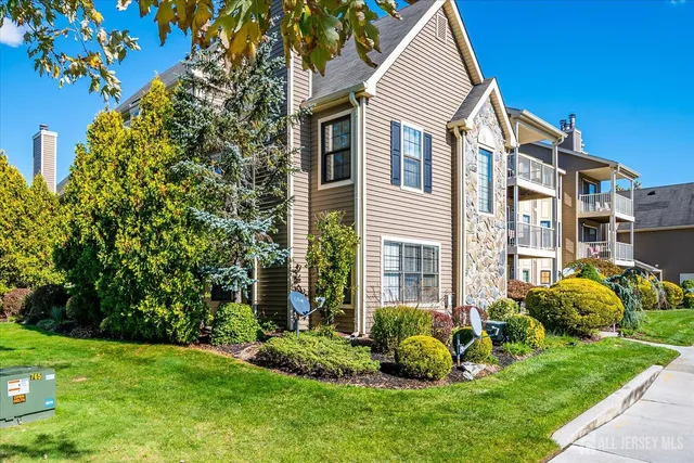 a front view of a house with a garden and plants