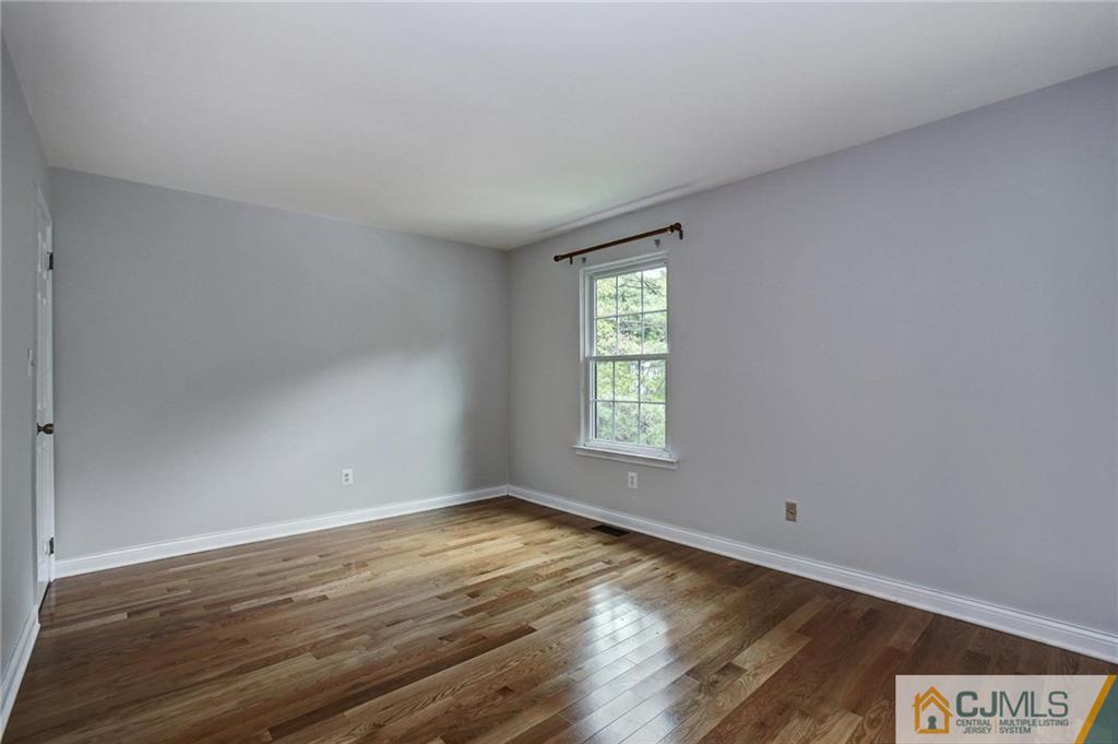 1902 Timber Oaks Road Edison, NJ 08820 - Photo 14 of 22 an empty room with wooden floor and windows