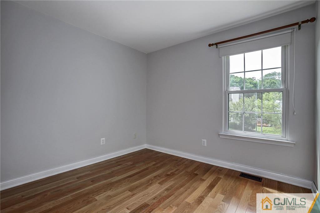 1902 Timber Oaks Road Edison, NJ 08820 - Photo 19 of 22 an empty room with wooden floor and windows