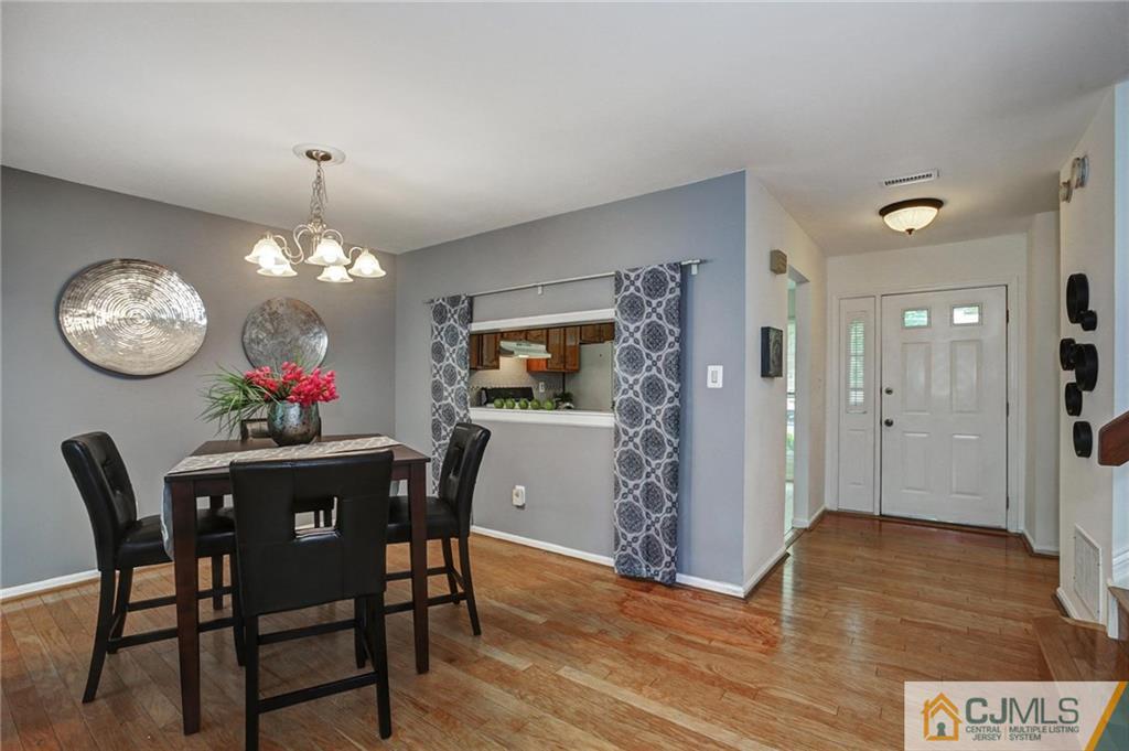 1902 Timber Oaks Road Edison, NJ 08820 - Photo 4 of 22 a dining room with wooden floor a chandelier a wooden table and chairs