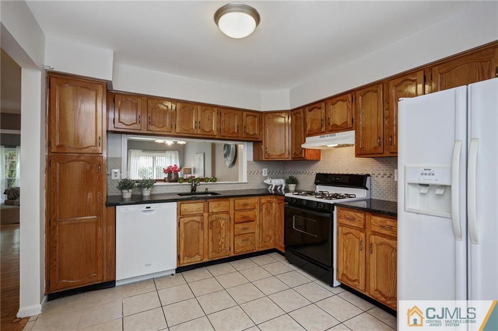 1902 Timber Oaks Road Edison, NJ 08820 - Photo 10 of 22 a kitchen with granite countertop a refrigerator stove top oven and sink