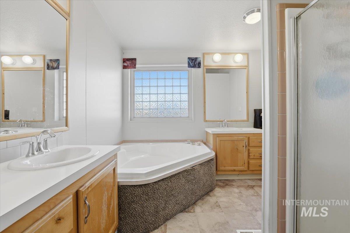545 South Conover Street Eagle, ID 83616 - Photo 19 of 39 Bathroom featuring two vanities, a shower stall, and a bath