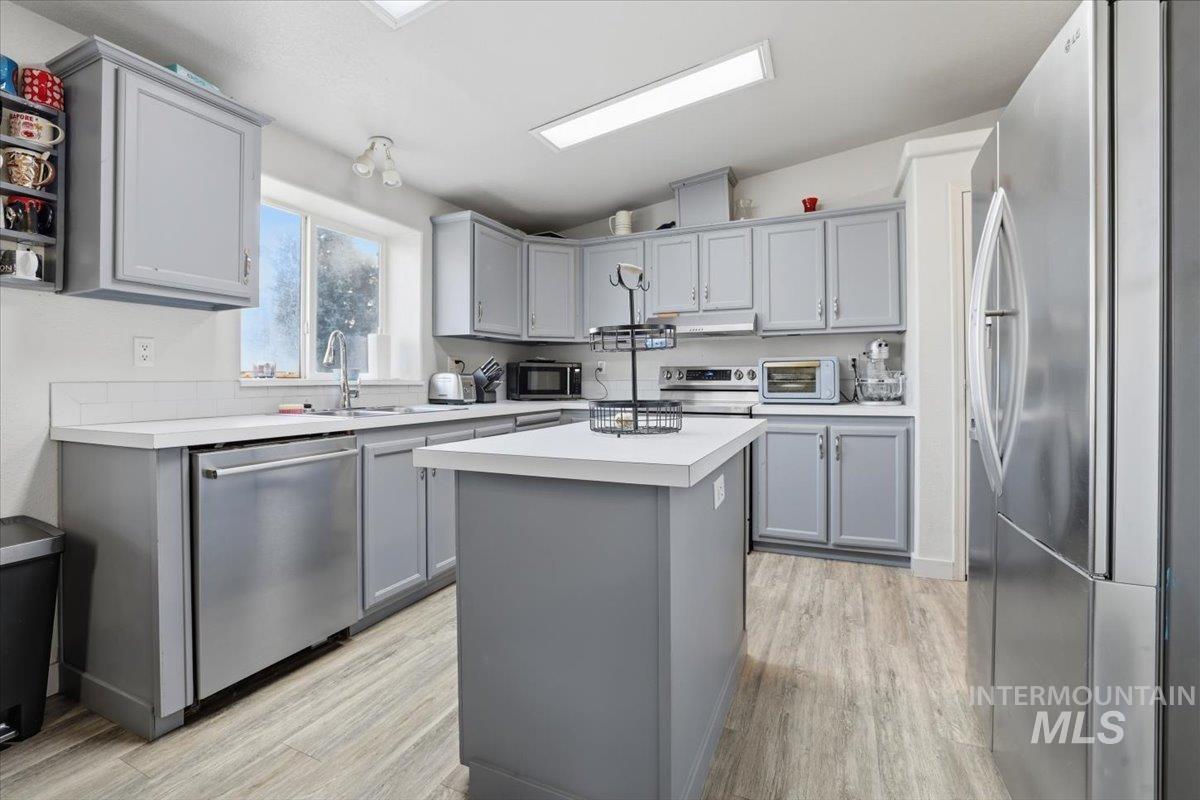 545 South Conover Street Eagle, ID 83616 - Photo 8 of 39 Kitchen with gray cabinetry, stainless steel appliances, light countertops, and lofted ceiling