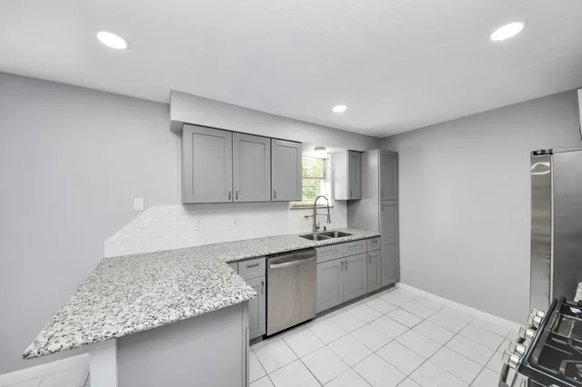 a kitchen with stainless steel appliances a stove a microwave and white cabinets