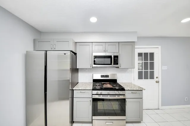 a kitchen with stainless steel appliances granite countertop a sink and a stove