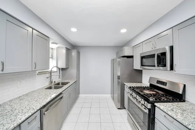 a kitchen with stainless steel appliances a refrigerator and a stove top oven