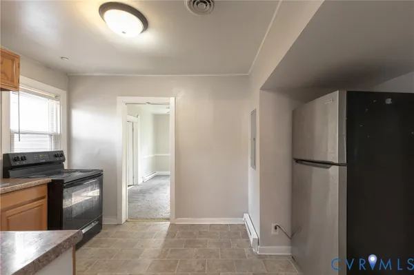 a view of a kitchen with refrigerator and wooden floor