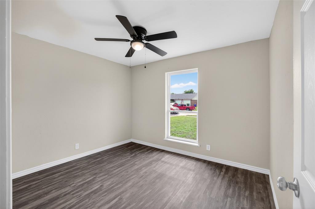 7528 Meadowlark Lane North Watauga, TX 76148 - Photo 12 of 31 an empty room with wooden floor ceiling fan and windows