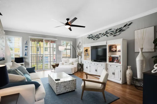 a living room with furniture a flat screen tv and a large window