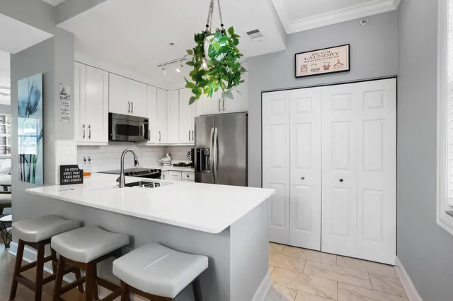 a kitchen with a refrigerator a stove a sink dishwasher and microwave with wooden floor