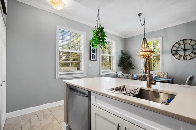 a kitchen with a sink a chandelier and window