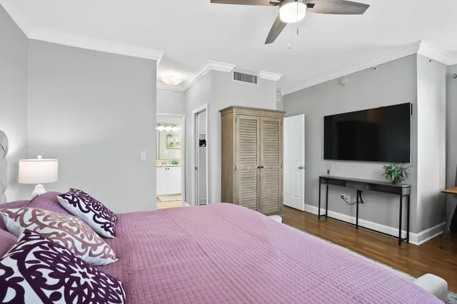 a bedroom with a bed and a flat tv screen on dresser