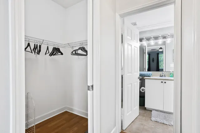 a view of walk in closet with wooden floor