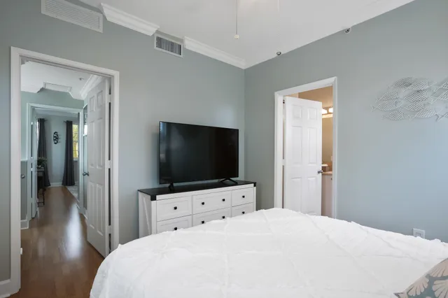 a bedroom with a bed and a flat tv screen on wall