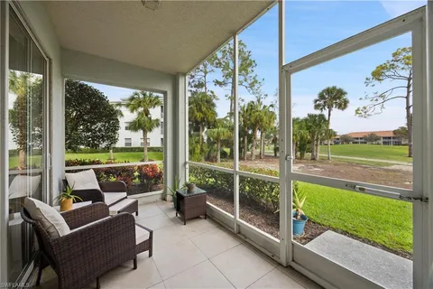 a living room with garden view and a floor to ceiling window
