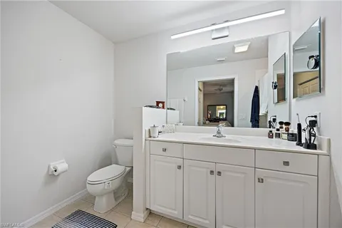 a bathroom with a granite countertop sink mirror and toilet