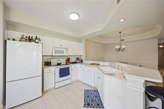 a kitchen with a white refrigerator stove a sink dishwasher and white cabinets with wooden floor