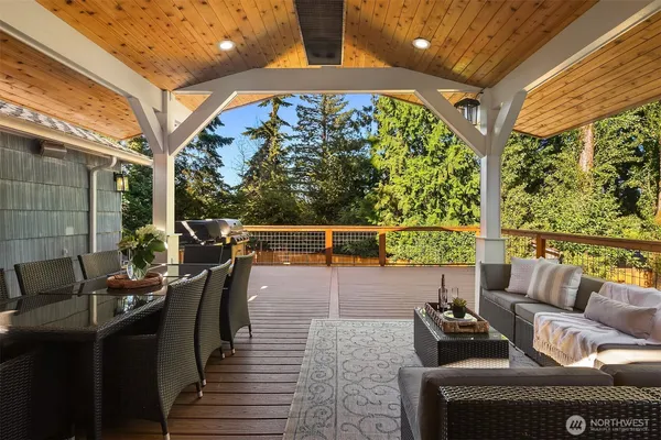 a roof deck with couches and wooden floor