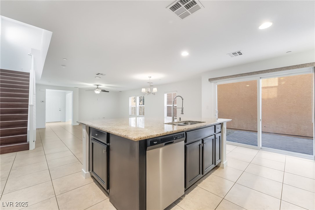 3052 Camino Rico Avenue Henderson, NV 89044 - Photo 16 of 39 Kitchen featuring an island with sink, dishwasher, light stone counters, ceiling fan, and light tile patterned floors