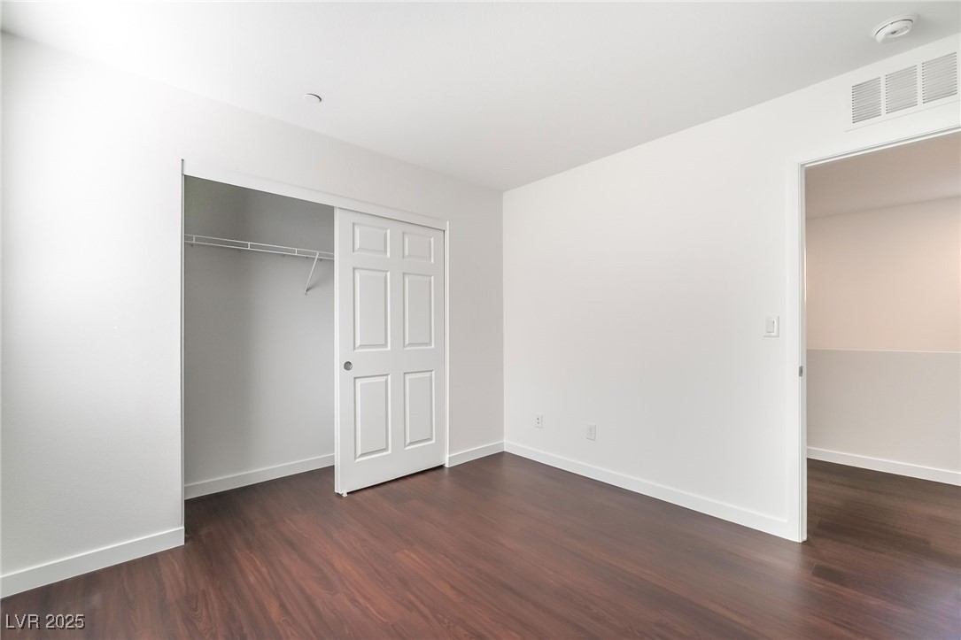 3052 Camino Rico Avenue Henderson, NV 89044 - Photo 28 of 39 Unfurnished bedroom featuring dark wood-style flooring and a closet