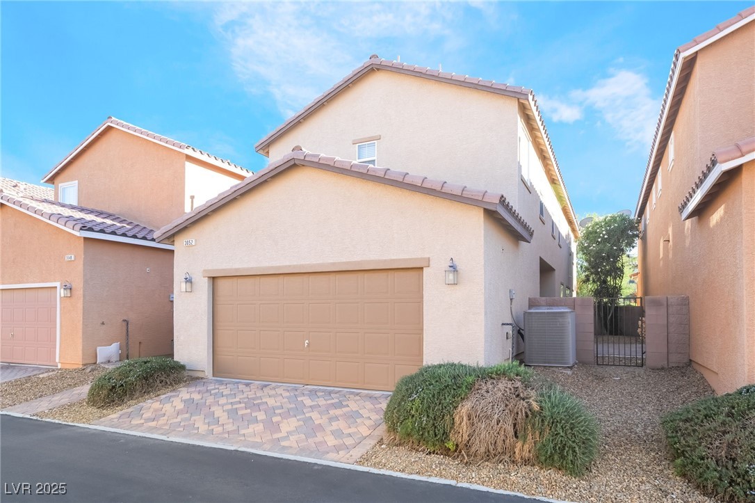 3052 Camino Rico Avenue Henderson, NV 89044 - Photo 39 of 39 View of front facade featuring stucco siding, decorative driveway, and a garage